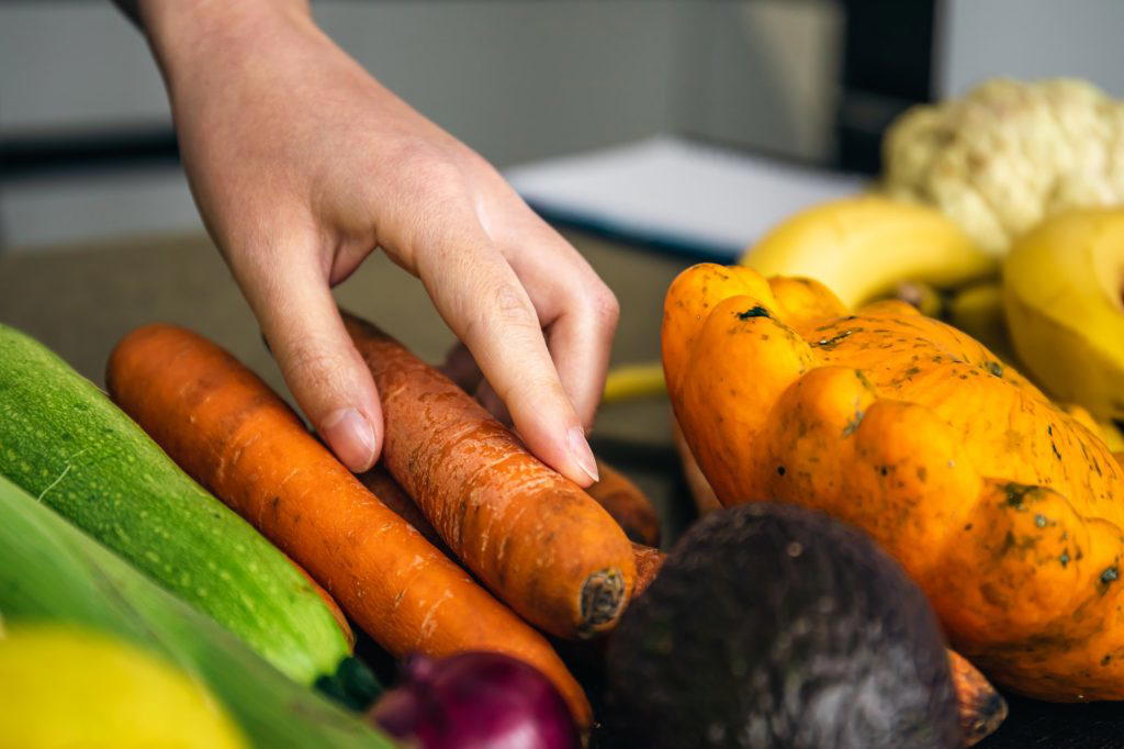Close-up, a woman's hand takes a carrot for cooking.